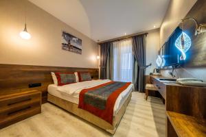 a hotel room with a bed and a desk at Ornella Butik Otel in Edremit