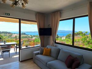 a living room with a couch and large windows at LASSI Apartment 1 in Argostoli