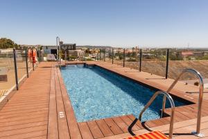 a swimming pool on a deck with a wooden deck at The Place Bodega Real by ALEGRIA in El Puerto de Santa María