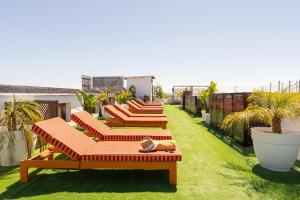 a row of lounge chairs on the roof of a building at The Place Bodega Real by ALEGRIA in El Puerto de Santa María