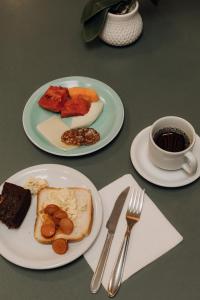 a table with two plates of food and a cup of coffee at Hotel Daieli in Otacílio Costa