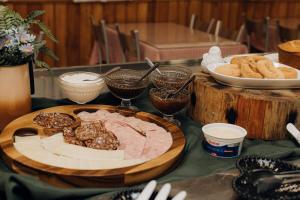 a table topped with a plate of meat and bread at Hotel Daieli in Otacílio Costa