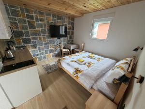 a small bedroom with a bed and a kitchen at Studio Apartman Tea, Žabljak in Žabljak