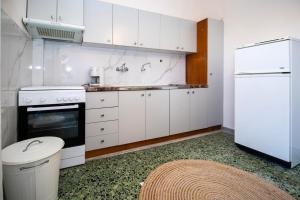a kitchen with white cabinets and a white refrigerator at Jonathan Central Apartment in Pefkochori
