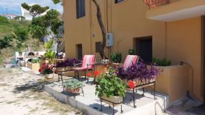 a group of chairs and flowers sitting outside of a building at LASSI Apartment 1 in Argostoli