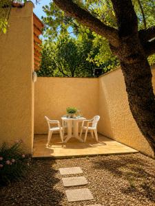 a table and chairs on a patio under a tree at Charmant studio avec terrasse in Fréjus