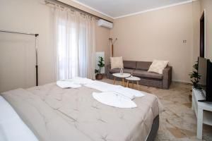 a large white bed in a room with a couch at Jonathan Central Apartment in Pefkochori +20 photos
