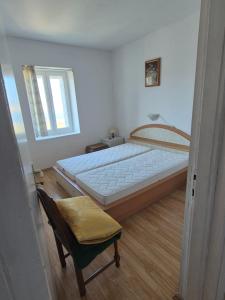 a bedroom with a large bed and a chair at Holiday Home Albina in Kustići