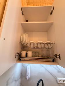 a kitchen with plates and dishes on shelves at Loreta's Canyon Farmhouse in Martvili +50 photos