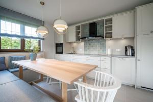 a kitchen with a wooden table and white cabinets at Ferienhaus Reet & Meer N 1 in Bansin +21 photos