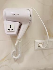 a hairdryer hanging on a wall in a bathroom at Loreta's Canyon Farmhouse in Martvili