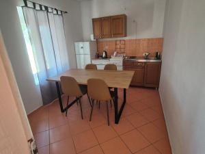 a small kitchen with a wooden table and chairs at Holiday Home Albina in Kustići