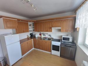 a kitchen with wooden cabinets and white appliances at U Cáfi Valtice in Břeclav +11 photos