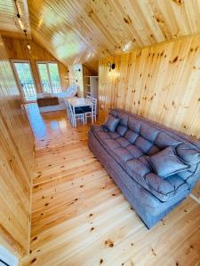 a living room with a couch in a wooden house at Loreta's Canyon Farmhouse in Martvili