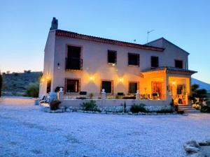 a large white house in the middle of a field at Casa Nuestra Roca in Vélez-Rubio