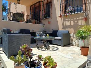 a patio with a table and chairs and potted plants at Casa Nuestra Roca in Vélez-Rubio +3 photos