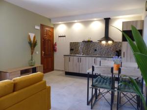 a kitchen and living room with a couch and a table at Casa Nuestra Roca in Vélez-Rubio