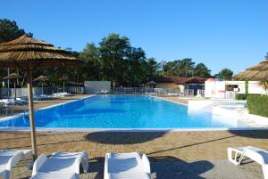 a swimming pool with chairs and an umbrella at VVF Labenne - Océan in Labenne