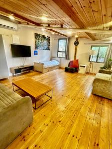 a large living room with a wooden floor at Tzimmer B'Kfar הצימר בכפר in Kefar Pines