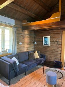 a living room with a blue couch and wooden walls at Reine Harbour Cabins in Moskenes