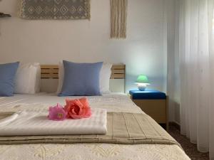 a bedroom with a bed with a pink rose on it at Kalelia in Nea Potidaea