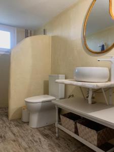 a bathroom with a toilet and a sink and a mirror at Kalelia in Nea Potidaea