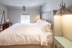 a bedroom with a white bed and a window at 16 Ulph Place in Burnham Market
