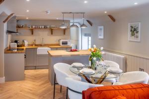 a kitchen and dining room with a table and chairs at 16 Ulph Place in Burnham Market