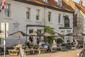 a group of people sitting at tables in front of a building at 16 Ulph Place in Burnham Market