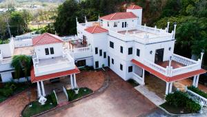 an aerial view of a white house with red roofs at Luxury Puerto Caribe Boutique Hotel in Aguada