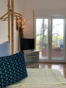 a bedroom with a bed and a desk and sliding glass doors at Kalelia in Nea Potidaea
