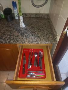 a red tray with utensils on a counter at Casa tranquila y segura in Santa Fe