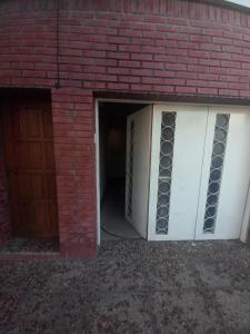 a brick building with a garage with a door at Casa tranquila y segura in Santa Fe +9 photos
