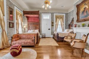 a bedroom with two beds and a couch and a fireplace at The Montgomery B&B in Starkville