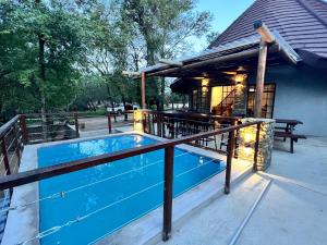 a swimming pool on a deck next to a building at The ChaBo Lodge in Marloth Park