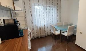 a dining room with a blue table and white chairs at VLC Apartment in Bucharest