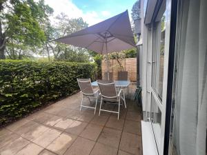 a table and chairs with an umbrella on a patio at Ferienwohnung Villa Fuchs in Dresden +4 photos