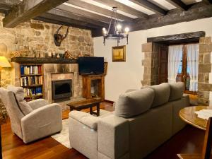 a living room with a couch and a fireplace at Posada la Punvieja in Los Tojos