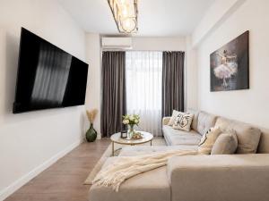a living room with a couch and a tv at Pop Up Aparthotel in Bucharest