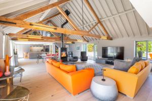 an open living room with orange couches and a tv at La Retraite in Wolferton