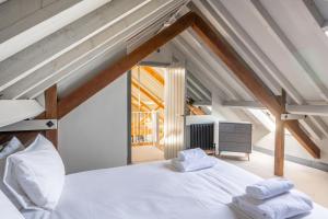 a bedroom with a white bed with two towels on it at La Retraite in Wolferton