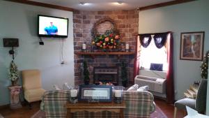 Hearthstone Inn في Lafayette: غرفة معيشة مع موقد وتلفزيون