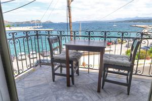 a table and two chairs on a balcony overlooking the water at Stella Di Mare Pylos in Pylos