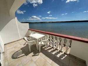 a balcony with a table and chairs on a boat at Apartment 2 (+1) in Ljubač