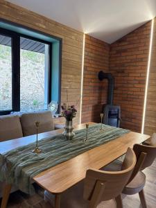 a dining room with a wooden table and a brick wall at Sky hugs cottage in Volosyanka