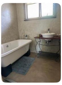 a bathroom with a bath tub and a sink at mission lifestyle in Empangeni +12 photos