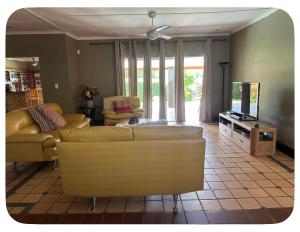 a living room with two couches and a tv at mission lifestyle in Empangeni