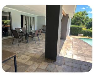 a patio with a table and chairs next to a pool at mission lifestyle in Empangeni