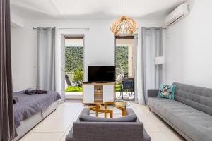 a living room with a couch and a tv at Lavender Bay E2-1-studio apartment in Donji Morinj
