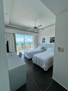 a hotel room with two beds and a balcony at Vista Mare Samaná in Punta Balandra +24 photos
